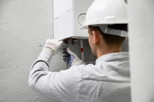 heating engineer fixing leaking boiler