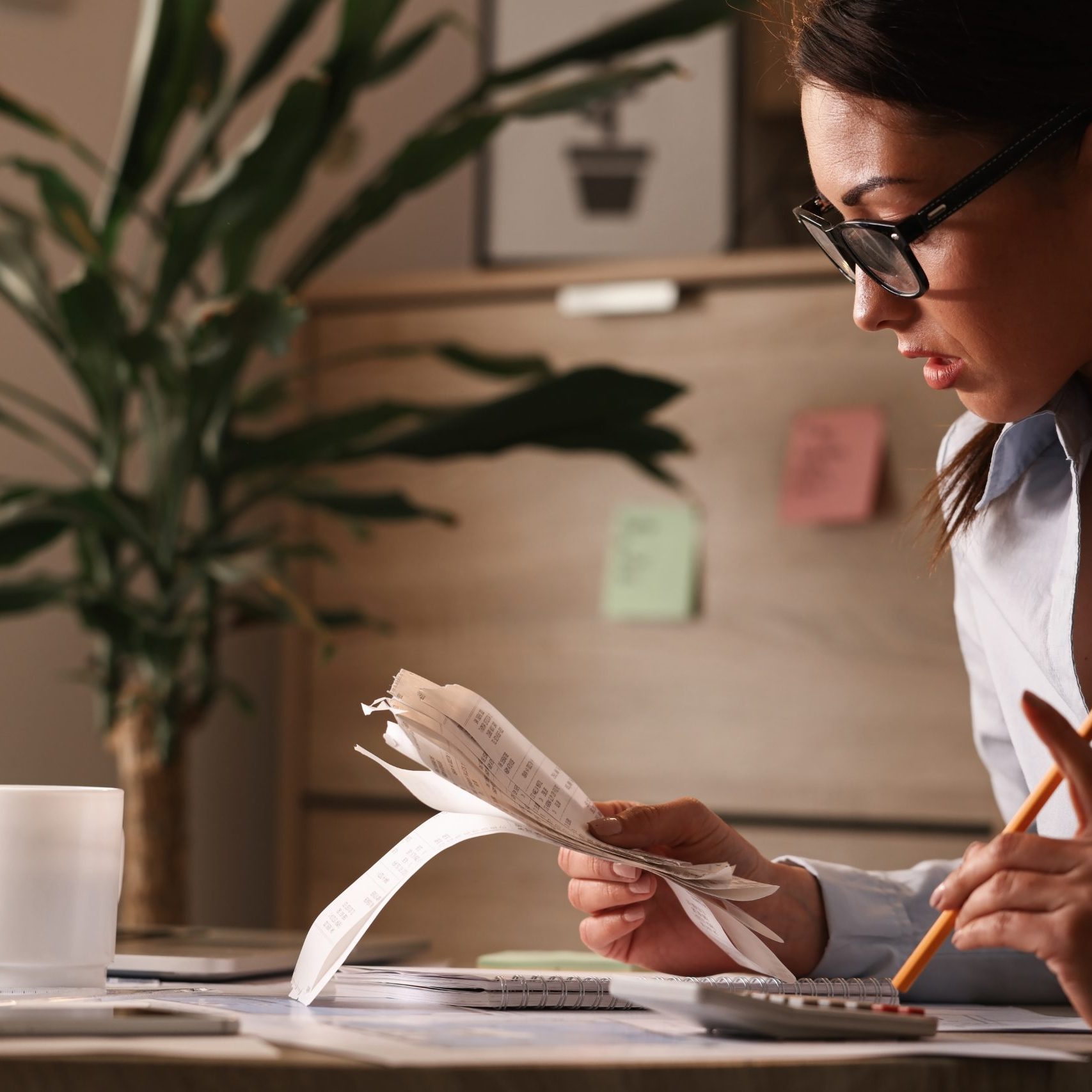 Female accountant calculating tax bills while working on finances in the office.