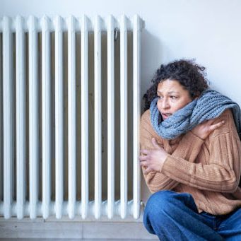 Black woman with home heating problem feeling cold